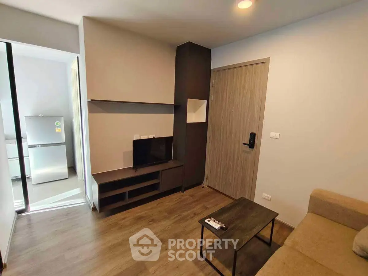 Modern living room with sleek furniture and open kitchen view in a stylish apartment.