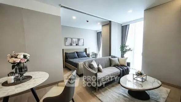 Luxurious open-plan living room with elegant decor and cozy bedroom area.