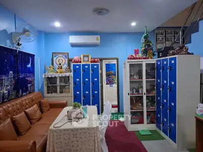 Cozy living room with leather sofa, lockers, and decorative elements in a vibrant setting.