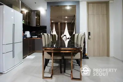 Modern kitchen with sleek dining area and mirrored backsplash