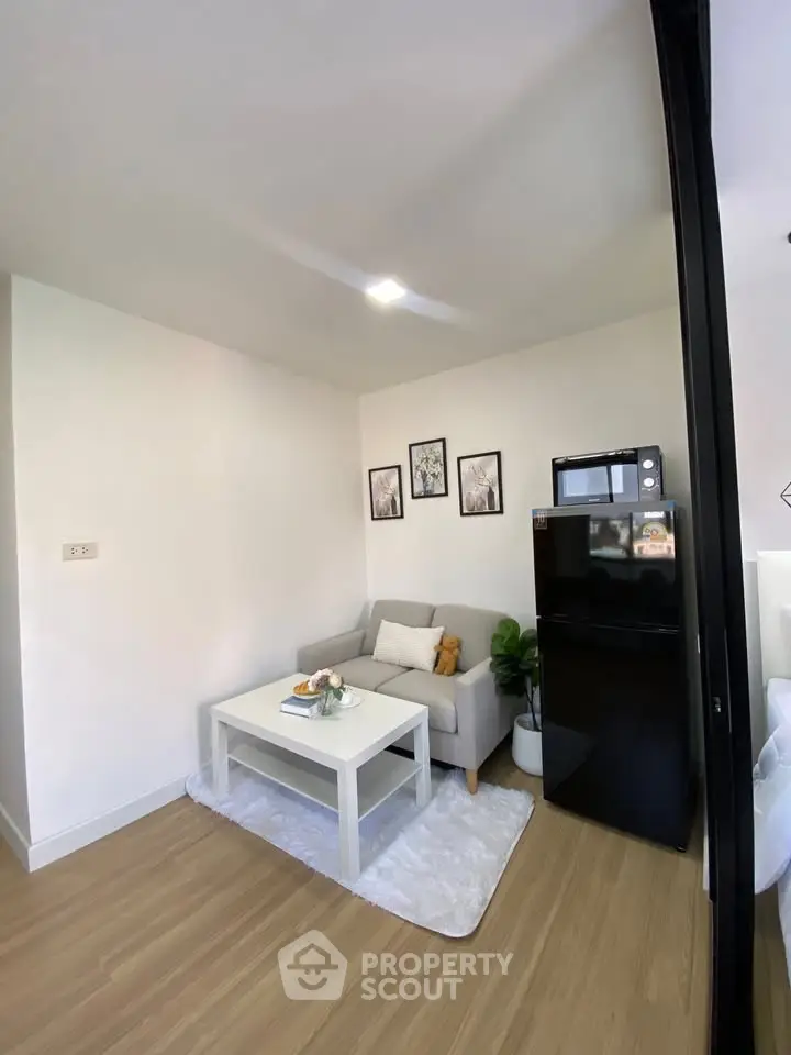 Cozy living room with modern decor and compact fridge, perfect for urban living.