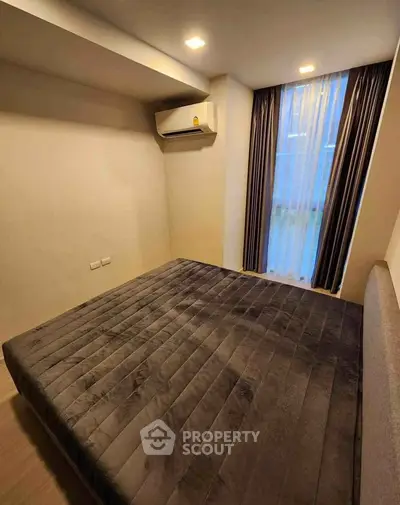 Cozy bedroom with modern air conditioning and elegant curtains, perfect for restful nights.