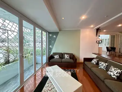 Spacious living room with large windows and modern decor in a stylish apartment.