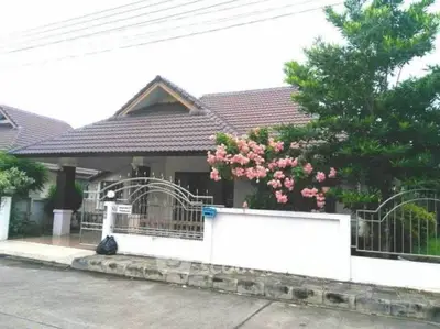 Charming suburban house with lush garden and tiled roof, perfect for family living.