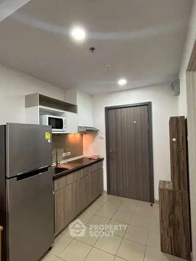 Modern compact kitchen with sleek appliances and wooden cabinetry