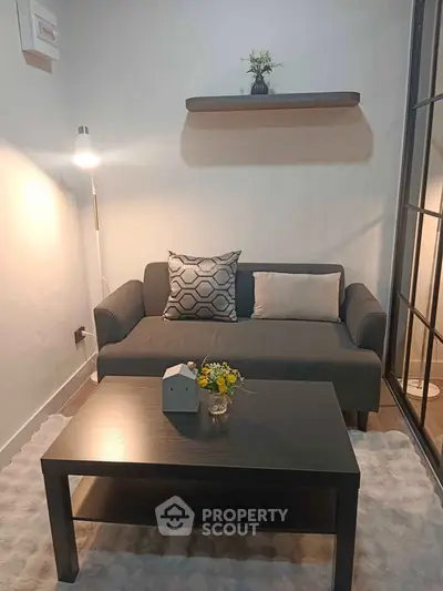 Cozy living room with modern gray sofa, stylish coffee table, and elegant decor accents.