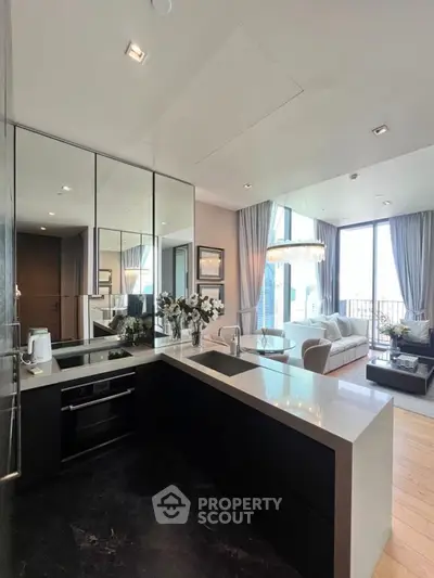 Luxurious open-layout kitchen and living room with modern decor and large windows.