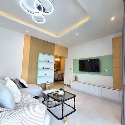 Modern living room with stylish lighting and wall-mounted TV, featuring cozy seating and elegant decor.