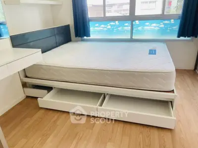 Modern bedroom with storage bed and large window with scenic view.