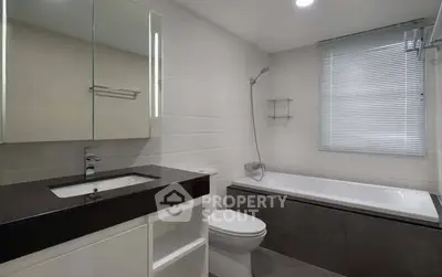 Modern bathroom with sleek design, featuring a bathtub and stylish vanity.