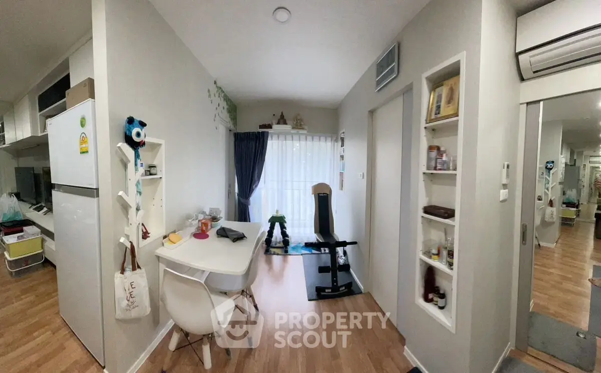 Modern apartment interior with dining area and exercise equipment, featuring sleek design and natural light.