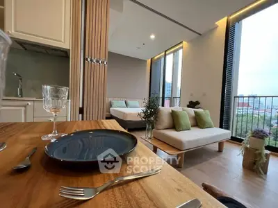 Modern open-plan studio with stylish decor and city view balcony, perfect for urban living.