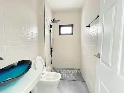 Modern minimalist bathroom with sleek shower and unique basin design.