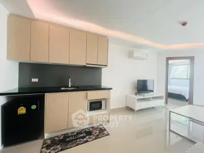 Modern open-layout living room with sleek kitchen and cozy bedroom view