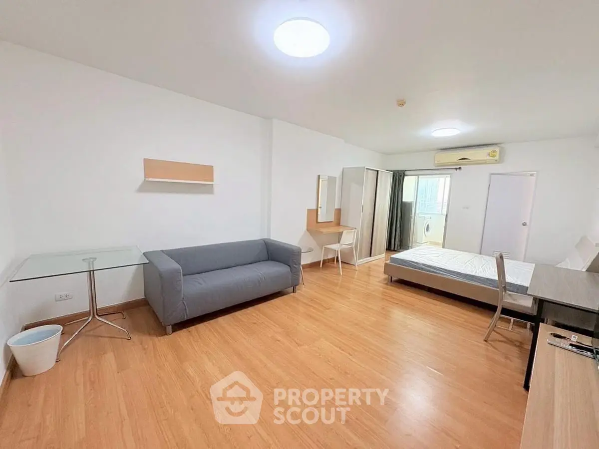 Spacious studio apartment with modern furnishings and wooden flooring, ideal for comfortable living.