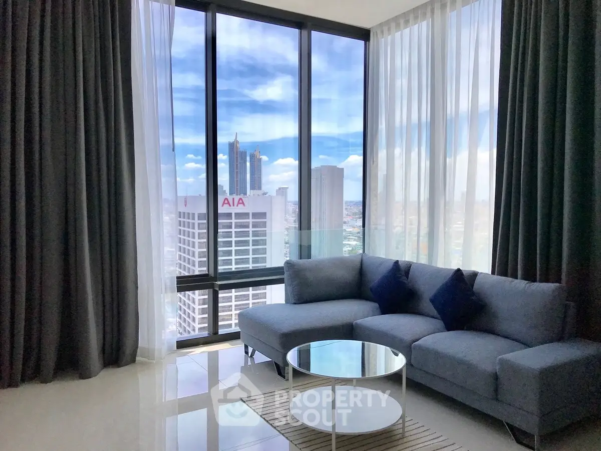 Luxurious living room with floor-to-ceiling windows offering stunning city views and modern furnishings.