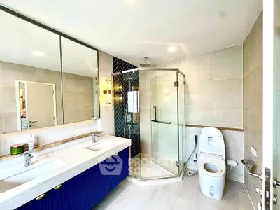Luxurious modern bathroom with dual sinks and glass shower enclosure