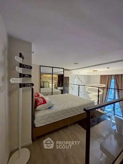 Modern bedroom with stylish decor and large mirror in a loft apartment.