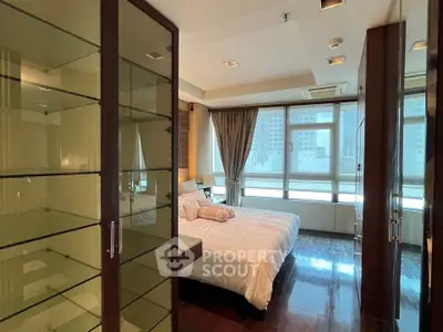 Luxurious bedroom with large windows and elegant decor in modern apartment.