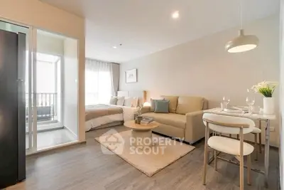 Modern open-plan living room with cozy seating and dining area, featuring a small balcony for natural light.