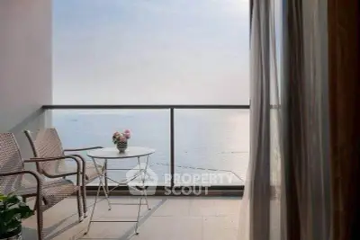 Stunning ocean view from a serene balcony with elegant seating, perfect for relaxation.