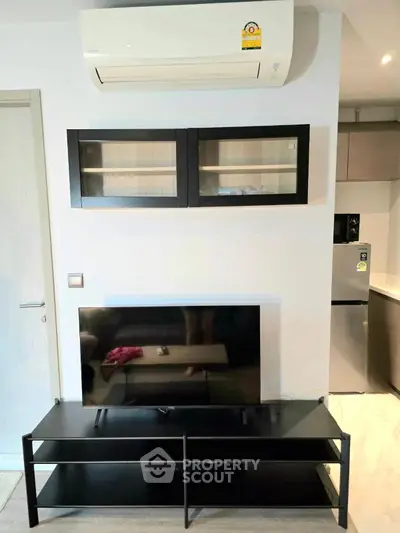 Modern living room with sleek black TV stand and wall-mounted air conditioner