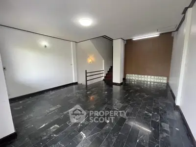 Spacious interior with sleek black marble flooring and modern staircase