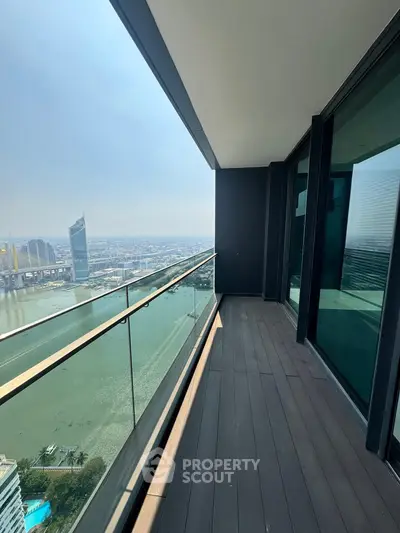 Stunning high-rise balcony with panoramic river view and modern glass railing.