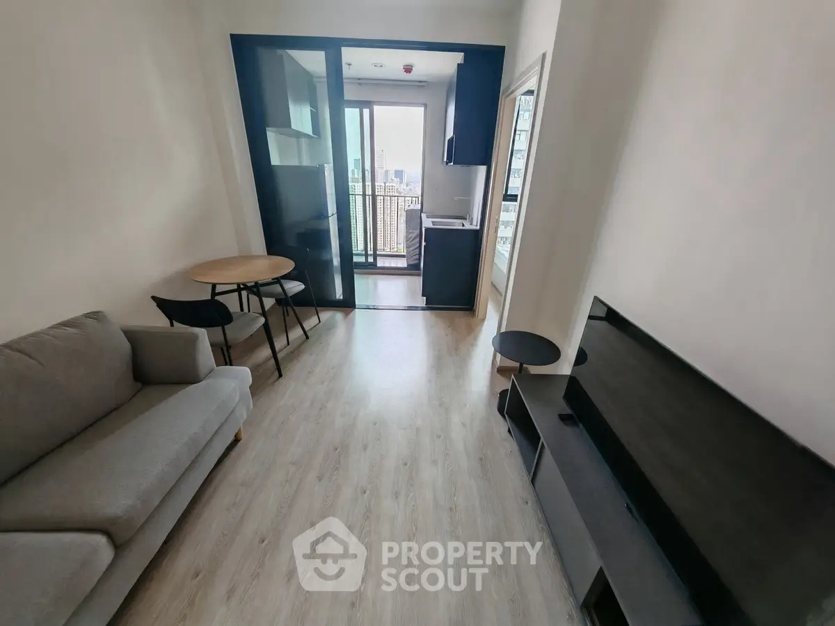 Modern living room with sleek furniture and balcony access in a stylish apartment.
