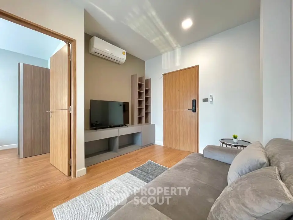 Modern living room with sleek design, featuring a cozy sofa, wall-mounted TV, and stylish wooden accents.