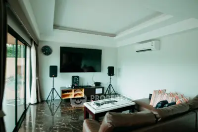 Spacious living room with modern entertainment setup and large TV
