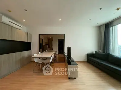 Spacious modern living room with sleek furniture and large windows offering natural light.