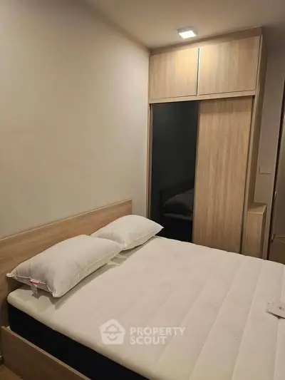 Cozy bedroom with modern wooden wardrobe and comfortable bed in a stylish apartment.