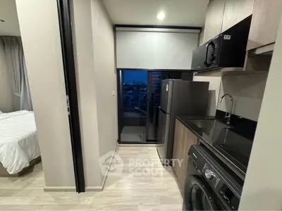 Modern kitchen with sleek appliances and adjacent bedroom view