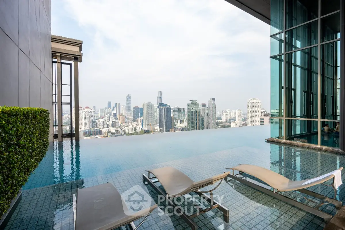 Luxurious rooftop infinity pool with stunning city skyline view, perfect for relaxation and leisure.