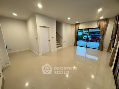 Spacious modern living room with large windows and elegant tile flooring