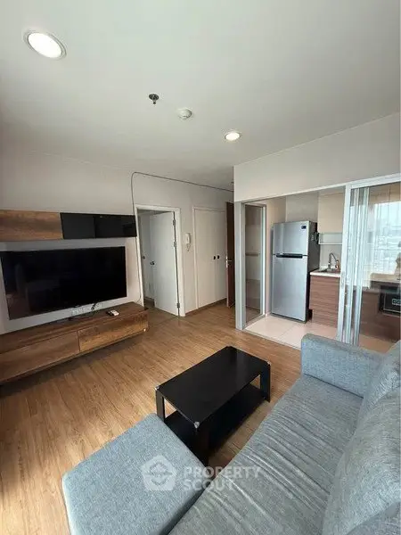 Modern living room with sleek furniture and open kitchen layout in a stylish apartment.