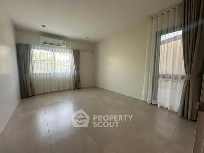 Spacious unfurnished room with large windows and tiled flooring, perfect for customization.