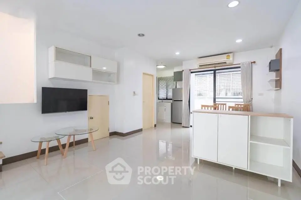 Spacious modern living room with open kitchen and natural light