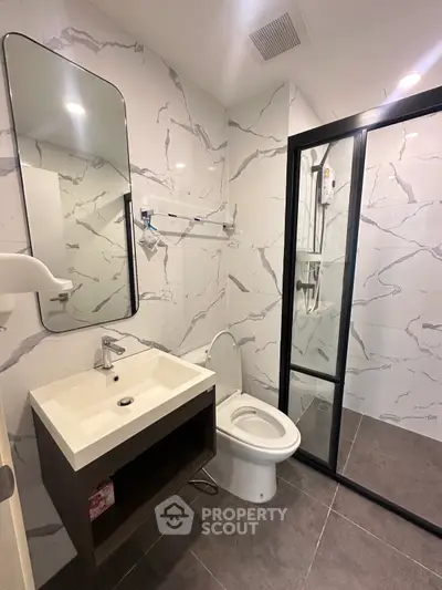 Modern bathroom with marble tiles and glass shower enclosure