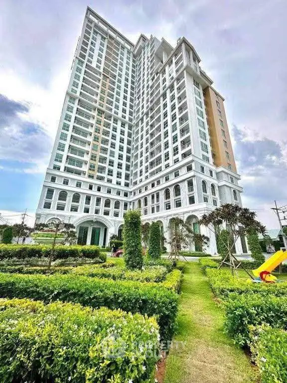 Luxurious high-rise building with manicured gardens and stunning architectural design.