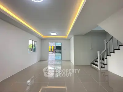 Spacious modern living room with sleek tile flooring and staircase
