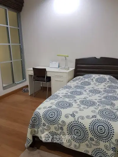Cozy bedroom with single bed and study desk, perfect for a student or professional.