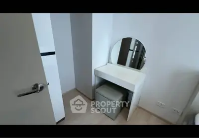 Modern minimalist bedroom with sleek vanity and mirror in a stylish apartment.