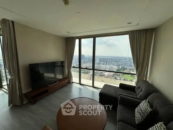 Spacious living room with panoramic city view and modern furnishings.