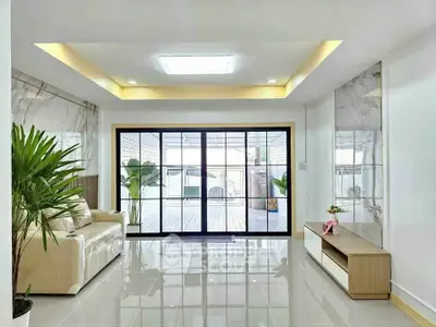 Spacious modern living room with large sliding glass doors and elegant decor.