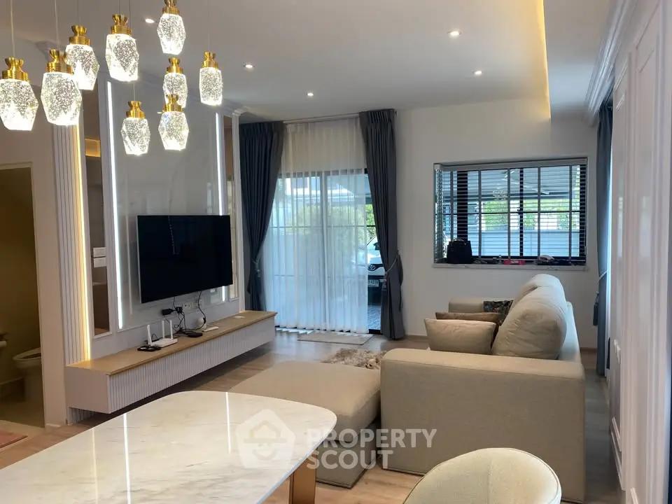 Luxurious living room with elegant lighting and modern decor, featuring a cozy sectional sofa and large TV.