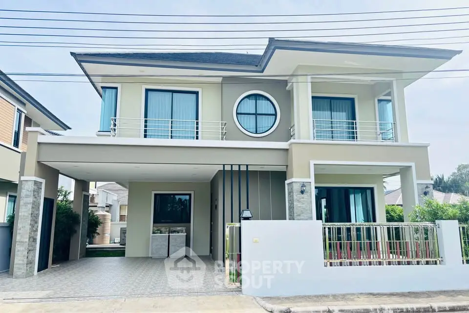 Modern two-story house with sleek design and spacious driveway in a suburban neighborhood.