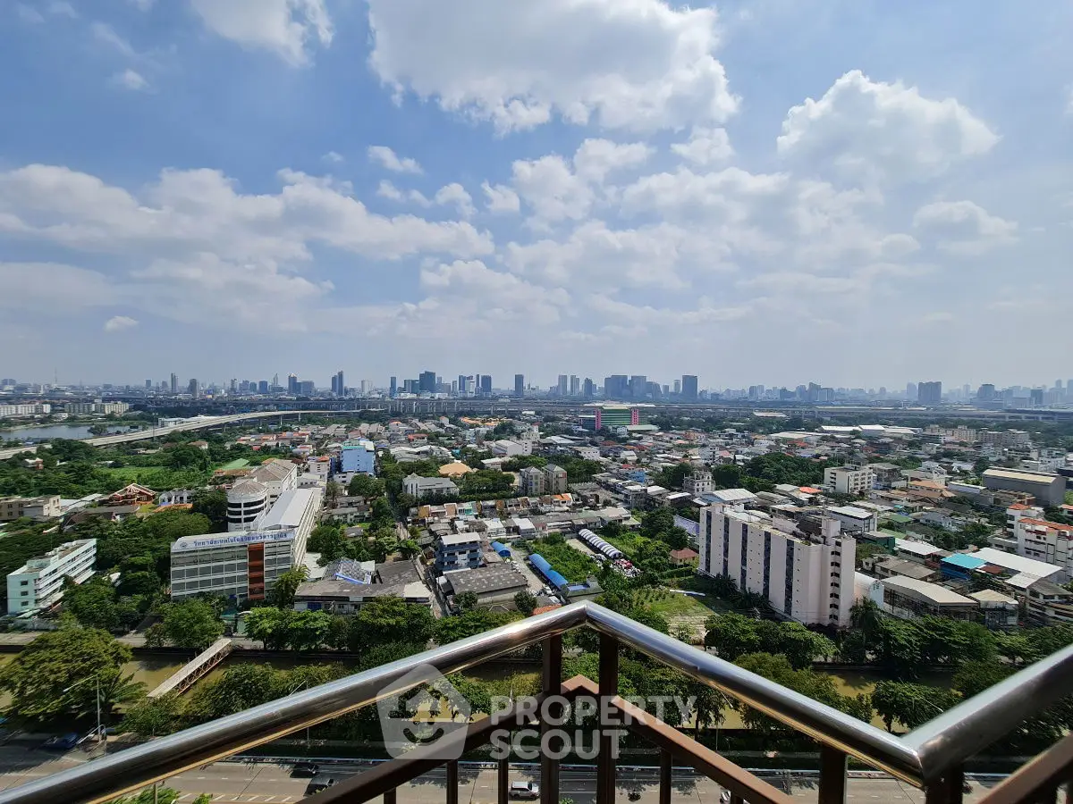Stunning panoramic city view from high-rise balcony with clear blue sky.