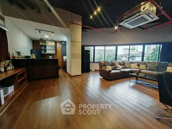 Spacious modern living room with wooden flooring and large windows